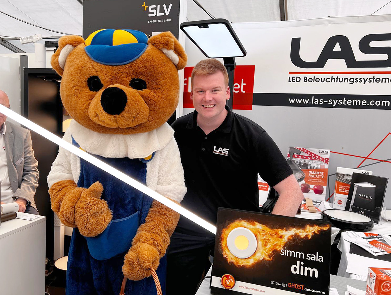 Tobias Hönerbach mit Korsing-Bär und LED Sanierungseinsatz TENEO auf dem LAS Messestand bei Korsing